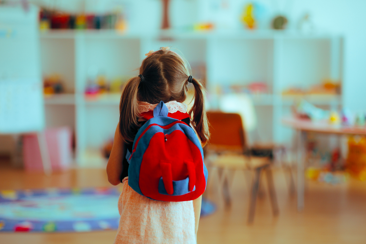Parent comforting young child with school anxiety before preschool drop-off