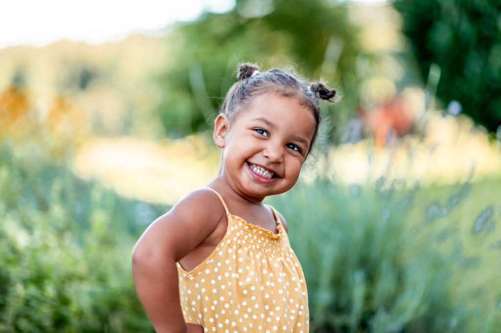 Smiling young child in a yellow dress outdoors — childhood independence