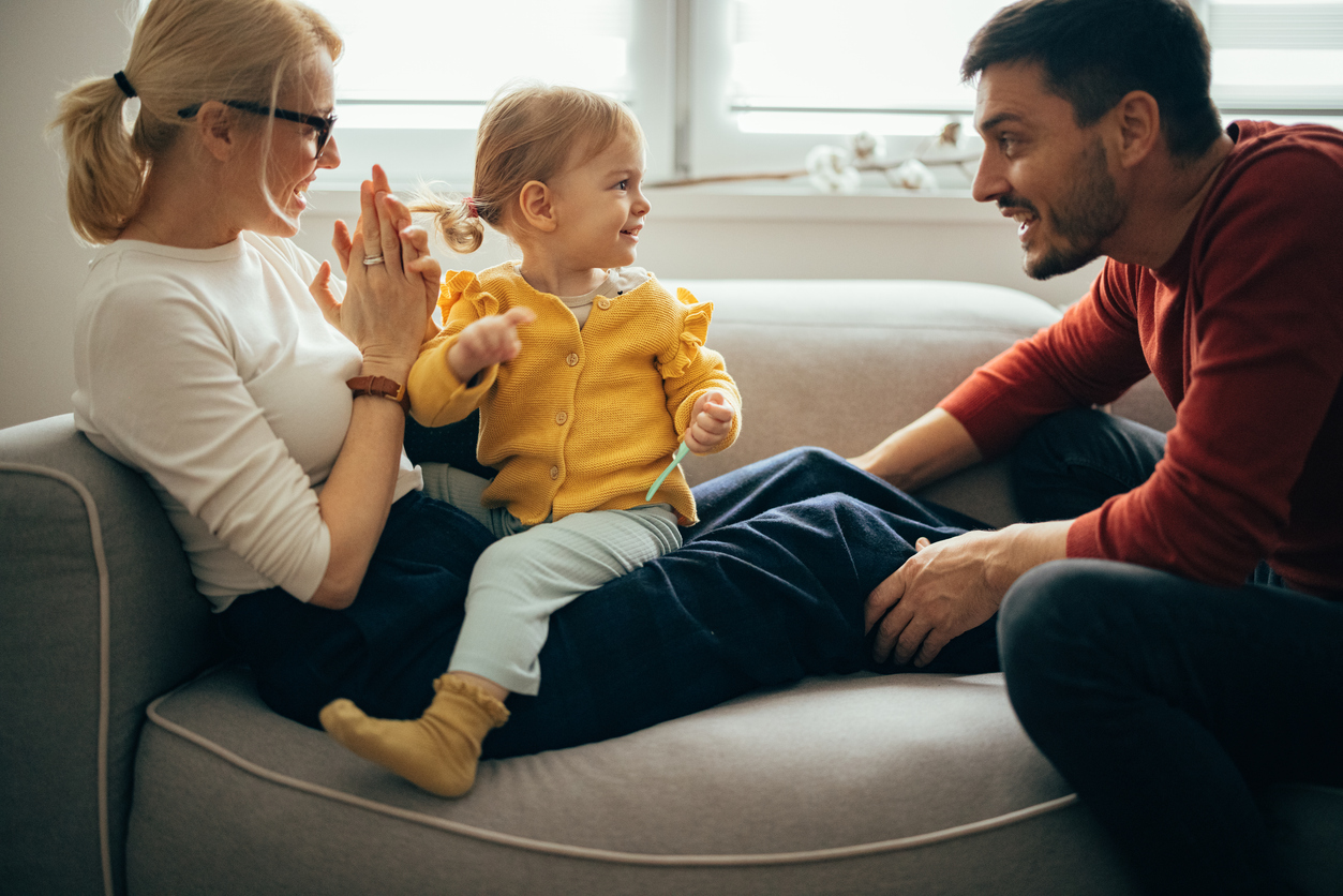 Parents encouraging a toddler during a calm, playful interaction that supports self-control development.