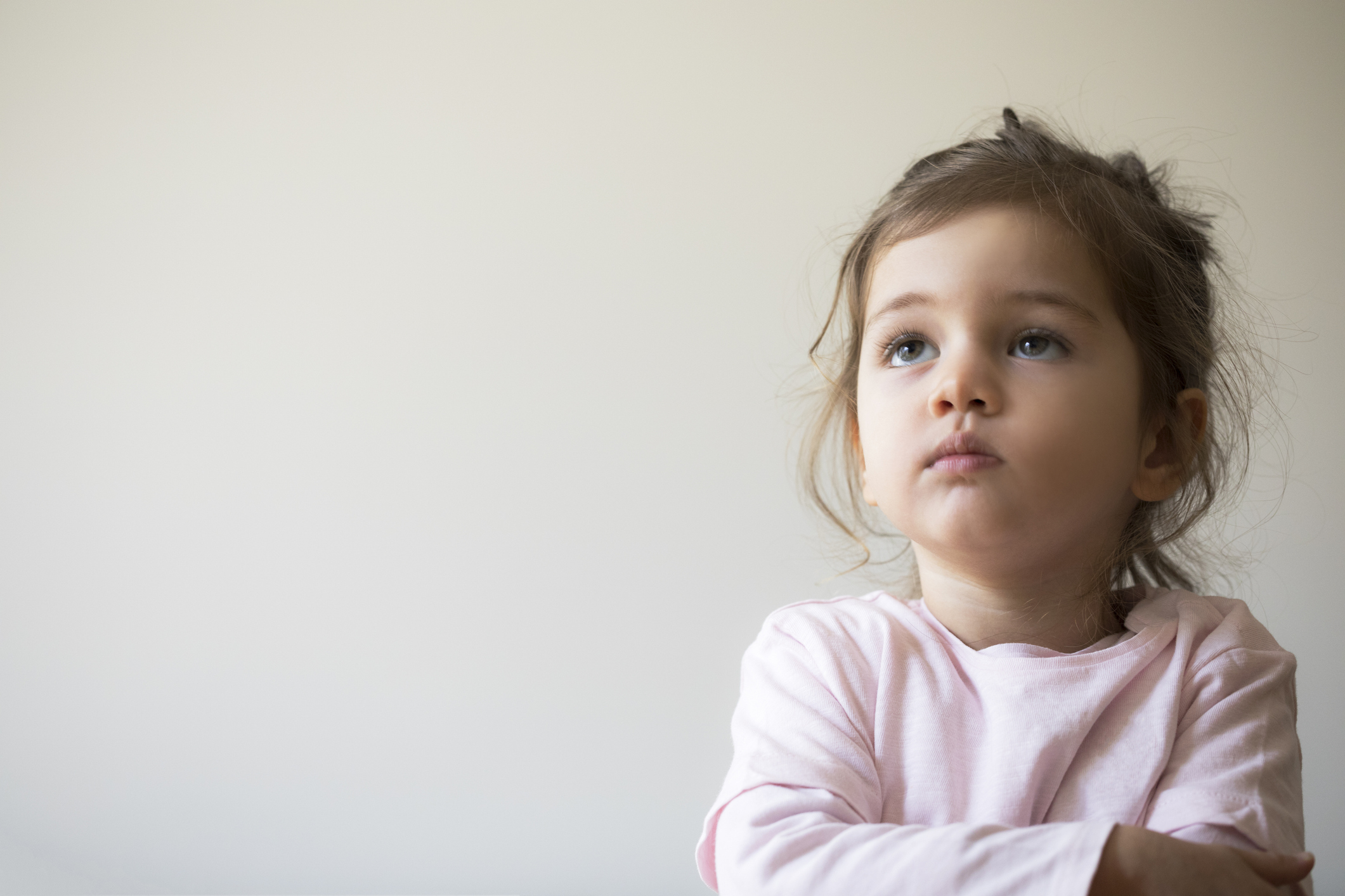 Young child with a thoughtful expression looking away, illustrating the emotions and developmental challenges behind why children lie and how parents can respond with empathy.