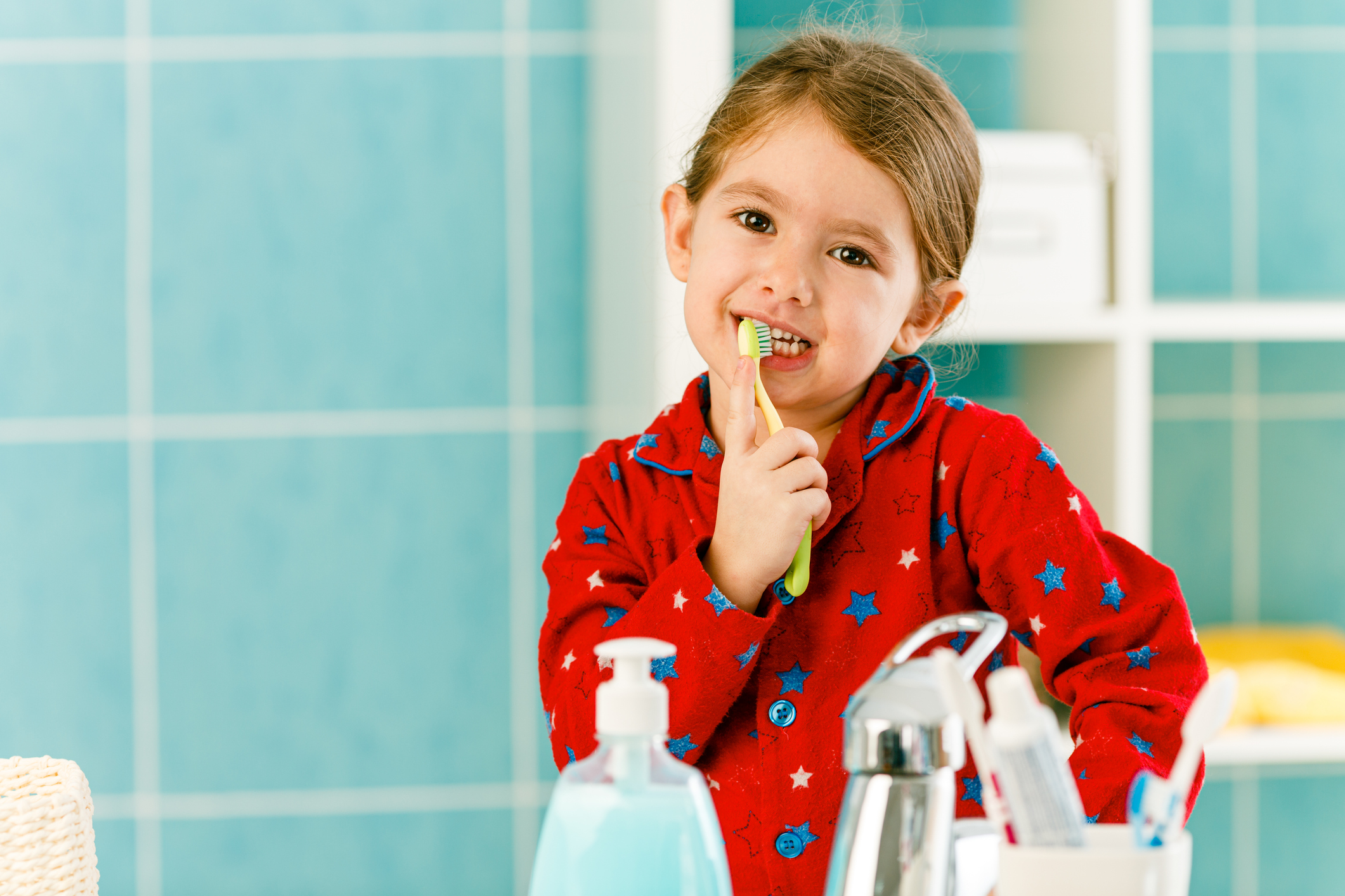 child brushing her teeth as part of a daily tooth care routine