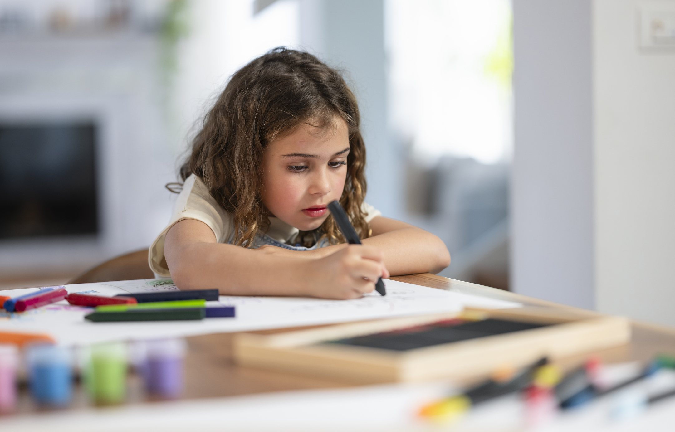 young child drawing with markers during a creative art activity that supports emotional development and self-regulation