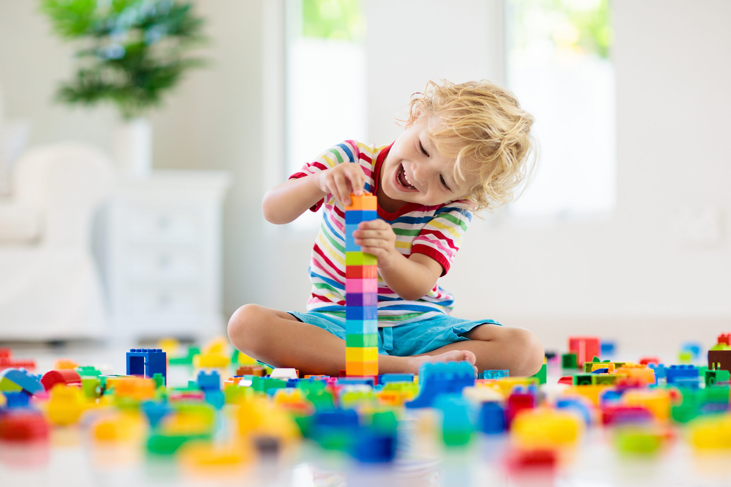 Preschool child stacking building blocks to create a tower